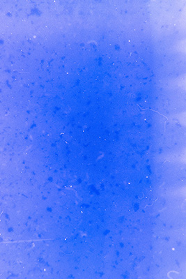 Blaues, strukturloses Bild mit kleinen Flecken. Am rechten Rand und oberen Bildbereich zieht sich ein hellerer Streifen entlang.