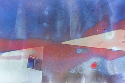 Modernes, weißes abstraktes Gebäude mit Fenster im Querformat. Überlagert von gräulich-blauen Farbflecken. Eine horizontale rote Farbspur verschmilzt mit der Architektur.